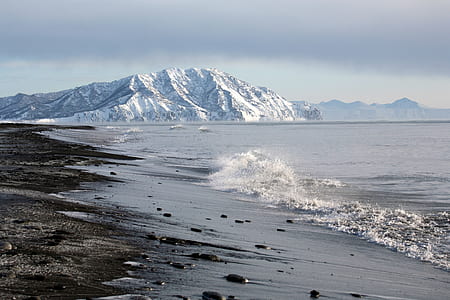 stones on seashore overlooking mountain range thumbnail