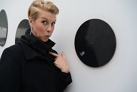woman standing beside round black disk thumbnail