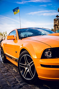 orange and black Ford Mustang with yellow and blue flag thumbnail