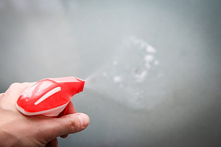 person holding red and white sprayer thumbnail