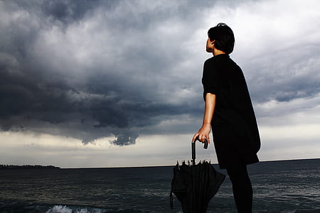 person in black shirt holding umbrella thumbnail