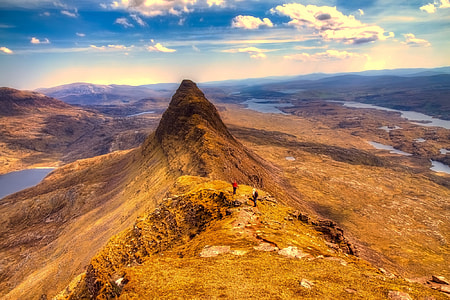 brown mountain under cloudy sky thumbnail