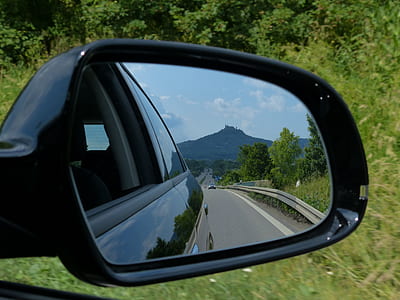 black vehicle side mirror with reflection of trees thumbnail