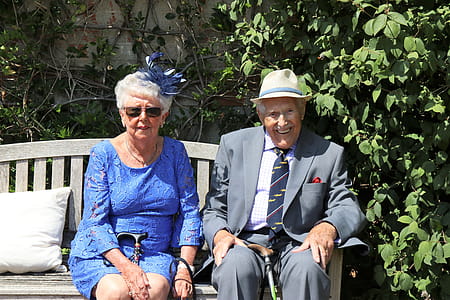 Woman Sitting Beside Man On WOoden Bench thumbnail