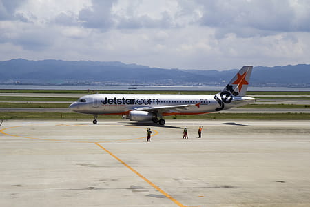 people standing near Jetstar plane on field during daytime thumbnail