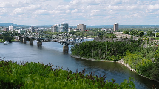 landscape photo of gray bridfe surrounded by trees and buildings thumbnail