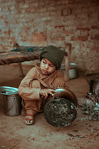 boy sitting on the ground while holding pot thumbnail