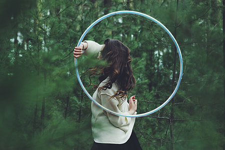 woman holding hula hoop in the middle of the forest thumbnail