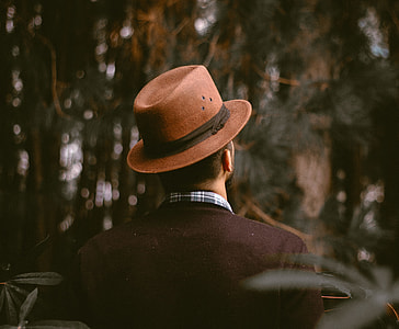 man wearing brown hat standing under tree thumbnail