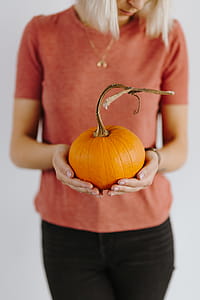 Women's hands in sweater are holding pumpkin thumbnail