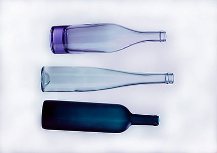 purple, black, and clear glass bottles with white background photo thumbnail