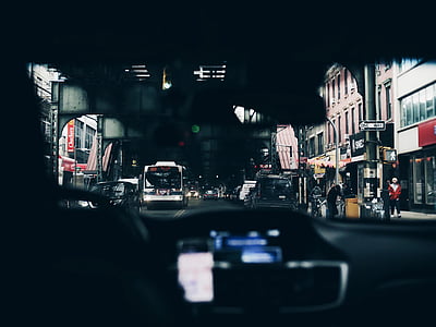 person inside vehicle taking photo of white bus on road thumbnail