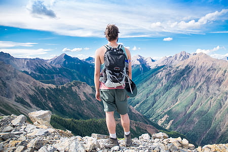 photo of man standing on top of mountains during day time thumbnail