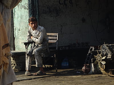 Man Wearing White and Gray Dress Shirt and Pant Sitting on Wooden Armchair thumbnail