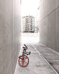 gray and red bicycle parked on alley thumbnail
