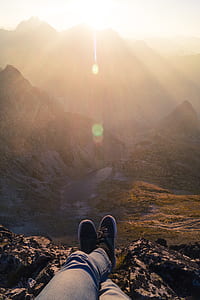 Person Wearing Black Sneakers Sitting in Mountain thumbnail