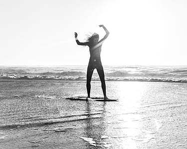 person riding surfboard on body of water thumbnail
