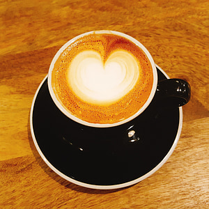 latte art in black ceramic coffee cup on saucer thumbnail