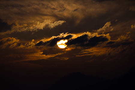 moon behind clouds at nighttime thumbnail