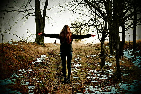 photo of woman standing beside bare tree thumbnail