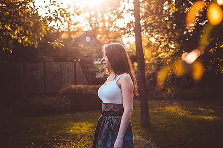 woman wearing white, brown, and green sleeveless dress standing during daytime thumbnail