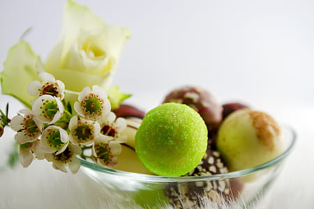 sweets and flowers in a clear glass bowl close up photo thumbnail