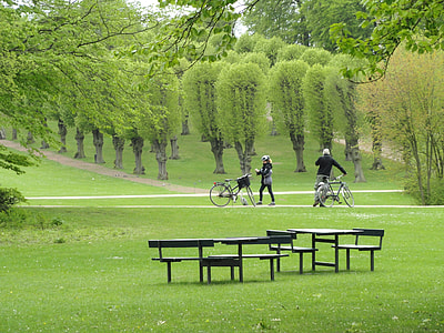 two people with bicycles near patio table sets during daytime thumbnail