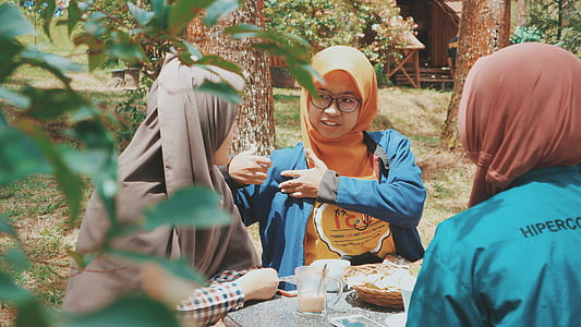 three person sitting in front of table beside tree thumbnail