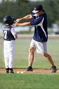 man teaching boy how to swing a bat on base during daytime thumbnail