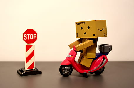 box man riding motor scooter with stop road sign toy thumbnail