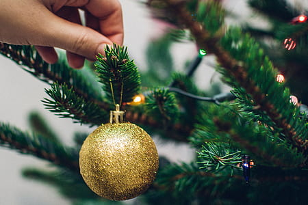 person holding beige christmas bauble thumbnail