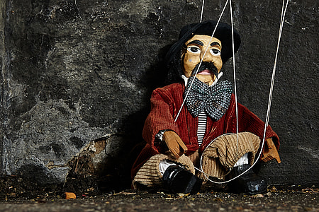 male string puppet leaning on black wall thumbnail