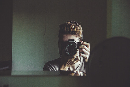 man holding a black DSLR camera thumbnail