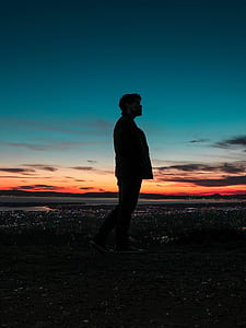 man standing near calm body of water thumbnail