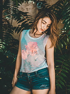 woman wearing white sheer sleeveless shirt looking downward thumbnail