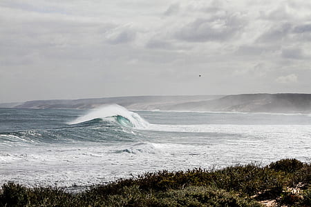 photo of heavy ocean waves under grey clouds thumbnail