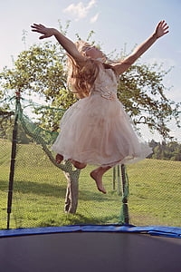 girl in pink dress jumping on trampoline thumbnail