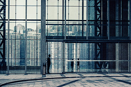 man standing beside the glass door of the building thumbnail