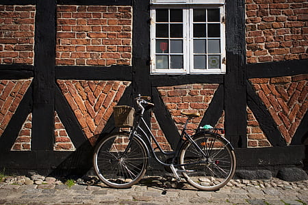 black beach cruiser bike near brown brick wall thumbnail