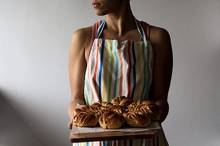 woman holding a tray with breads inside white room thumbnail