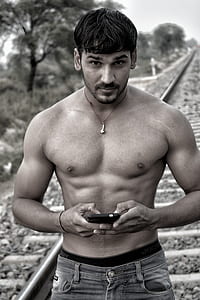 grayscale photo of man holding smartphone thumbnail