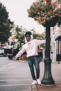 man holding pillar and standing on road at daytime thumbnail