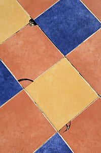 close up photo of orange, yellow, and blue floor tiles thumbnail