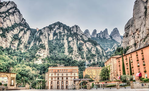 brown and gray concrete building near mountain under blue sky during daytime thumbnail