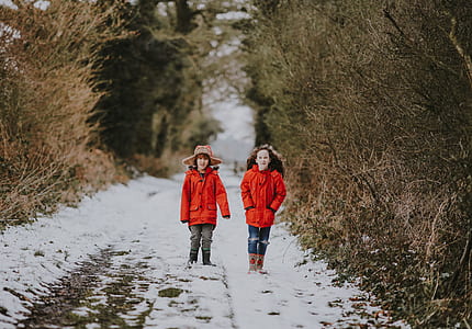 boy in red coat standing on road during daytime thumbnail