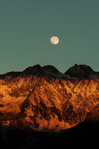 silhouette photo of mountains during full moon thumbnail