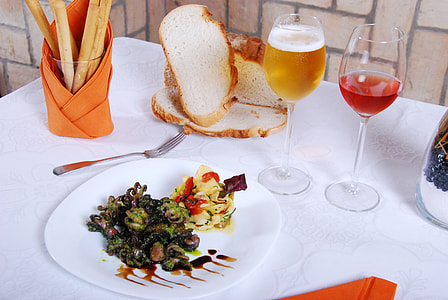 bread near plate with vegetable salad and two beer and wine filled wine glasses thumbnail
