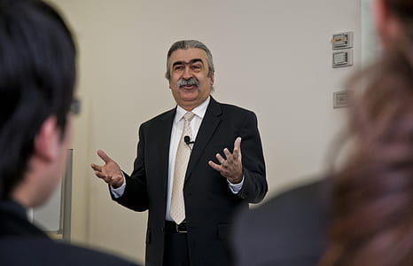 man in black suit standing in front of boy and girl thumbnail