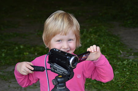 girl holding black Sony Handycam thumbnail
