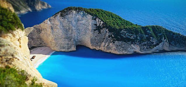 bird's eye view of mountain beside blue body of water thumbnail